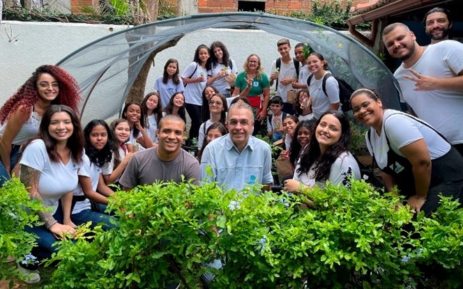 Grupo reunido em uma horta durante atividade de educação climática