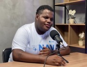 Jovem sorrindo durante a gravação do podcast